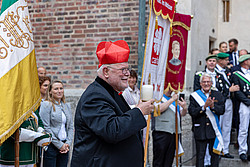 Mann mit Bier in der Hand vor Fahne