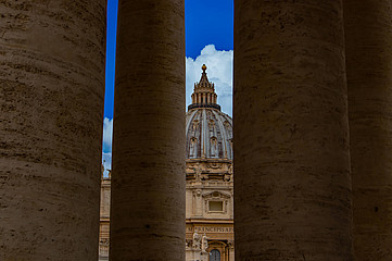 Blick auf die Kuppel des Petersdoms in Rom durch Säulen