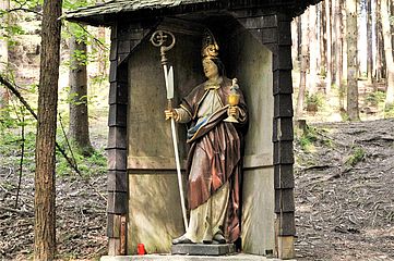 Heiligenfigur mit Bischofsstab, Messern und Kelch mit Jesuskind