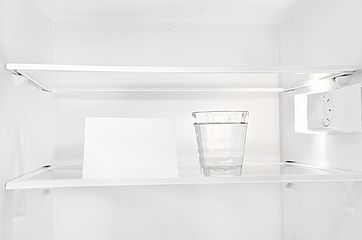  Wasserglas mit leerem Zettel im Kühlschrank 