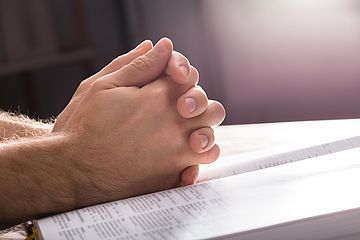 Betende Hände über Bibel