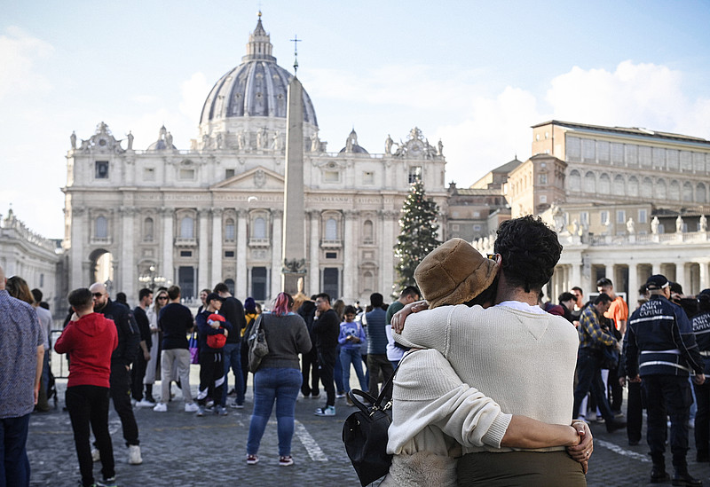 Menschen stehen hinter einer Absperrung, ein Paar umarmt sich, nach dem Tod des emeritierten Papstes Benedikt XVI. vor dem Petersplatz