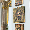 Drei Ikonen auf Holz hängen vertikal an einer Wand.