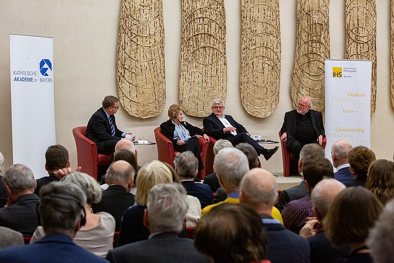 Madeleine Albright, Joschka Fischer und Kardinal Marx  sitzen nebeneinander auf einer Bühne.