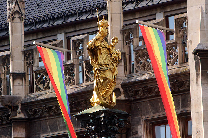 Regenbogenfahnen hinter der Marienstatue am Münchner Marienplatz