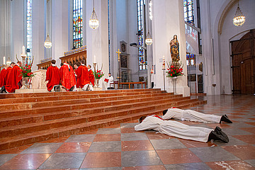 Zwei Männer liegen auf dem Bauch vor dem Altar