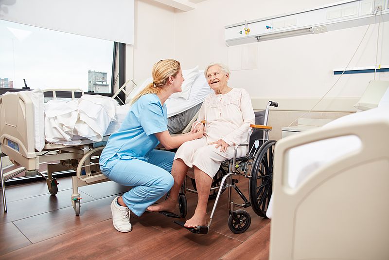Krankenschwester und Seniorin im Rollstuhl
