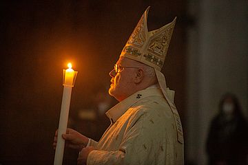 Kardinal Reinhard Marx mit Kerze in der Hand