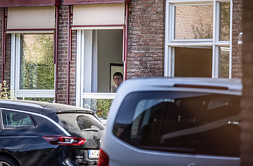 Kardinal Rainer Maria Woelki guckt aus dem Fenster des erzbischöflichen Hauses  in Köln, während Mitglieder der Staatsanwaltschaft Köln eine Durchsuchung im Haus durchführen.