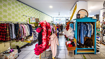 Verkaufsraum einer Filiale der Shopkette Vinty's, in dem Kleiderständer mit Secondhand-Mode herumstehen. 