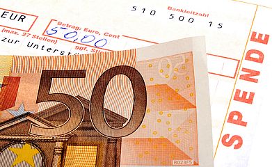 50-Euro-Schein und Spendenbescheinigung, auf der der Betrag von 50 € handschriftlich eingetragen wurde. (Symbolbild) 