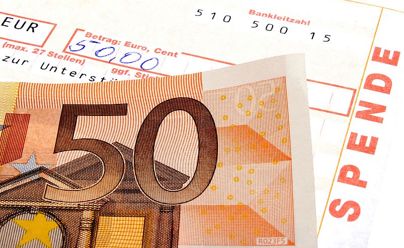 50-Euro-Schein und Spendenbescheinigung, auf der der Betrag von 50 € handschriftlich eingetragen wurde. (Symbolbild) 