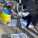 Gemeinsam beschriften die Demonstranten ihre Schilder.