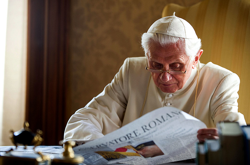 Papst Benedikt liest Zeitung am Schreibtisch
