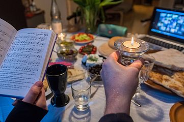 Gottesdienst zuhause: Liedbuch, Tisch mit Essen und Livestream