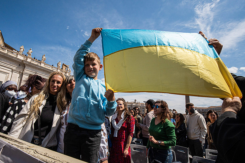 Menschen am Petersplatz halten Ukrainefahne