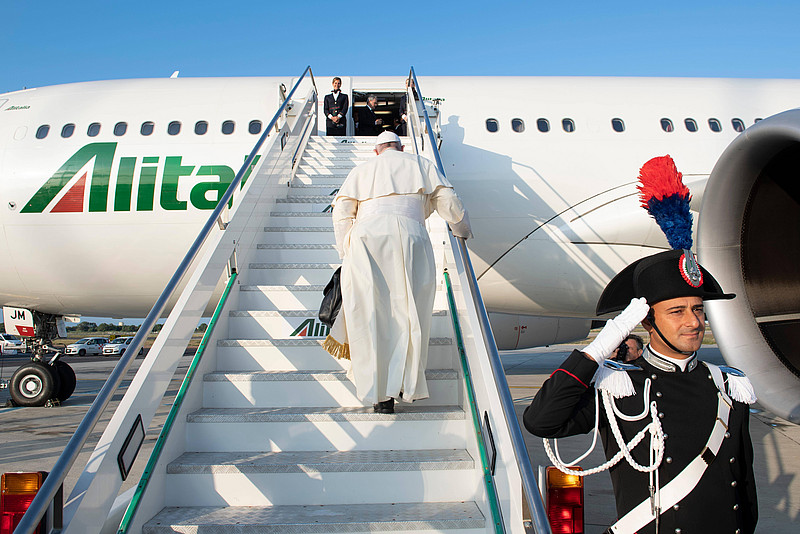 Papst Franziskus steigt die Treppen eines Flugzeugs hinauf. 