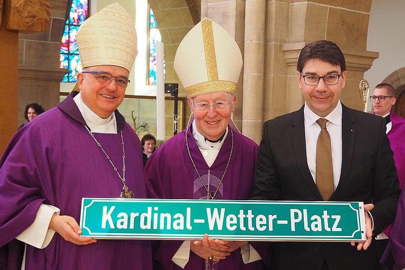 Der Speyerer Bischof Dr. Karl-Heinz Wiesemann, Kardinal Friedrich Wetter und Oberbürgermeister Thomas Hirsch (v.l.n.r.) halten ein Schild in der Hand auf dem "Kardinal-Wetter-Platz" steht. 