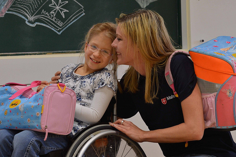 Schulbegleiterin mit Mädchen im Rollstuhl