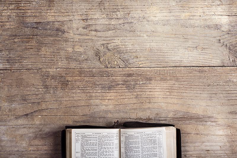 Offene Bibel auf Holztisch