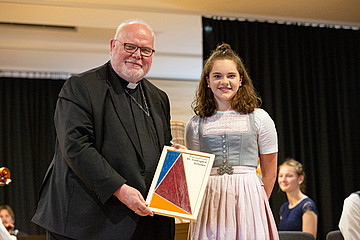 Kardinal Marx bekam von den Schülerinnen und Schülern das Logo der Irmengard-Schulen als Geschenk überreicht.