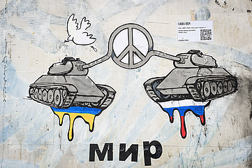 Streetart von zwei Panzern mit dem Friedenssymbol zwischen sich