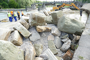 Steine und Bauarbeiter vor der Isar