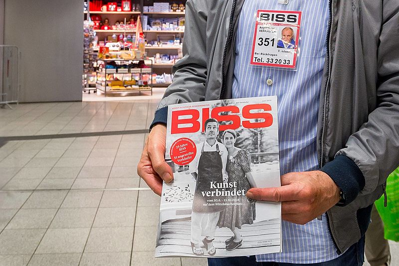 Ein Verkäufer bietet eine BISS-Zeitschrift an