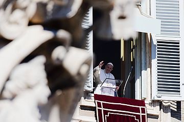 Papst Franziskus steht am Fenster und wink.