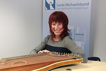 Portrait Monika Drasch mit ihrer Harfe im Studio des Münchner Kirchenradios