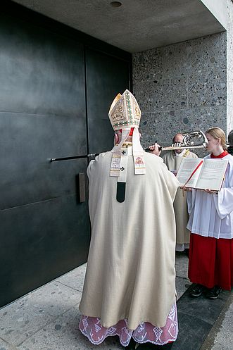Kardinal Reinhard Marx klopfte mit seinem Bischofsstab an das Kirchenportal.