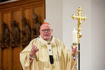 Kardinal Reinhard Marx vor einem Kreuz