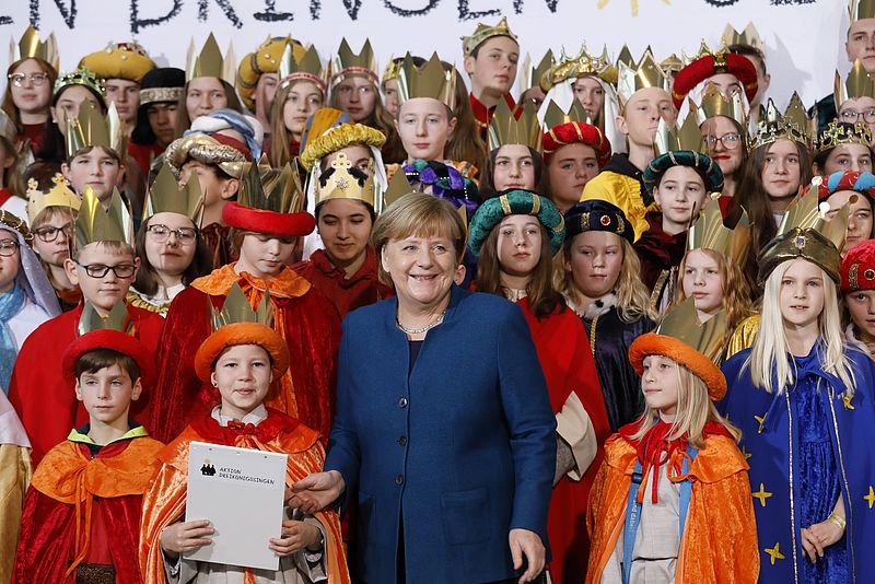 Bundeskanzlerin Angela Merkel mit Sternsingern