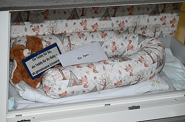 Die Babyklappe in Rosenheim, darin ein Babybett, ein Brief mit der Aufschrift 