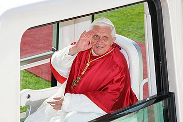 Der frühere Papst Benedikt XVI. winkt aus dem Papamobil.