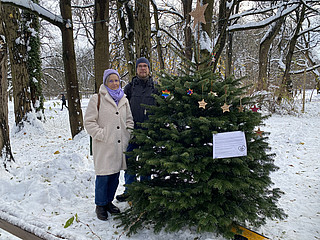 Mann und Frau vor einem Baum mit Anhängern