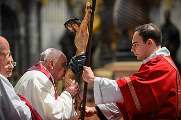 Papst Franziskus küsst ein Kruzifix