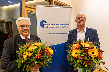 Armin Schalk (rechts) und Hans Tremmel mit Blumensträußen in der Hand