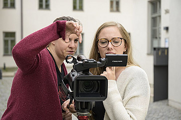 Zwei Frauen stehen hinter der Kamera und schauen auf ein Display