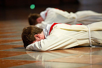 Zwei Männer liegen flach mit dem Bauch auf dem Boden