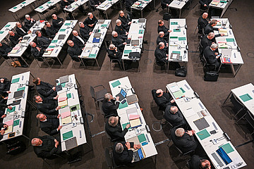 Bischöfe an langen Tischen im Sitzungssaal bei der Frühjahrsvollversammlung Deutschen Bischofskonferenz