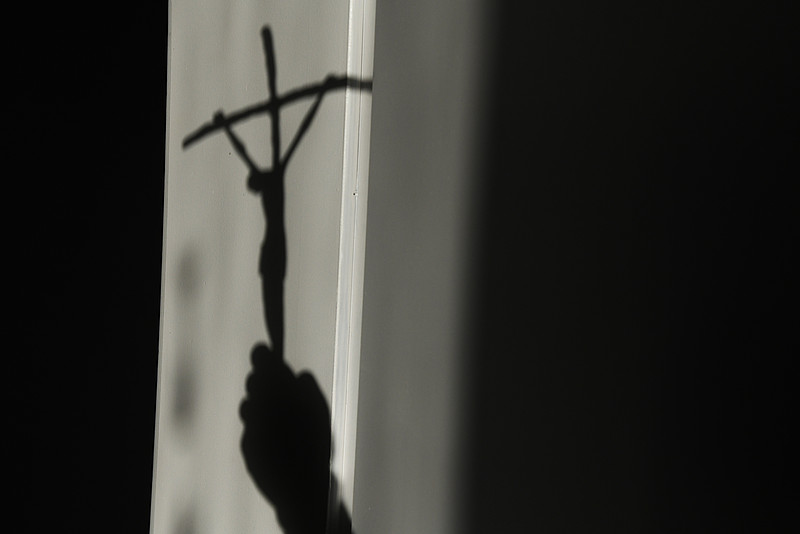 Schattenhand mit Kreuz