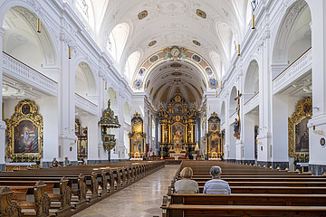 Großer Kirchenraum mit nur zwei Besucherinnen, die in Kirchenbank sitzen. 