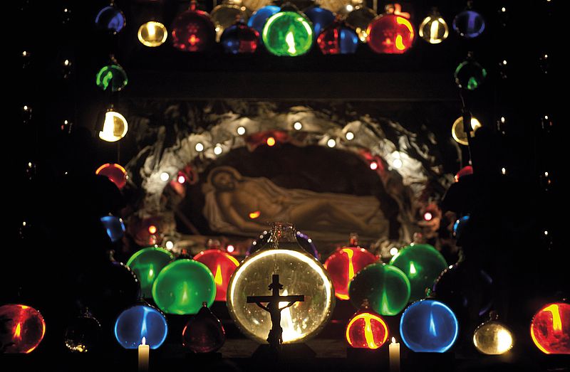 Das Heilige Grab in Höglwörth: Jesus Figur liegend, um ihn herum viele bunte leuchtenden Kugeln.