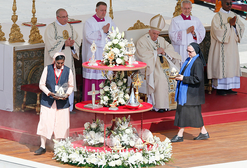 Papst Franziskus während der Heiligsprechung auf dem Petersplatz. Ordensschwestern bringen Reliquien der Heiligen zu einer blumengeschmückten großen Etagere. 