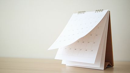 Tischkalender zum Umblättern auf einem Holztisch