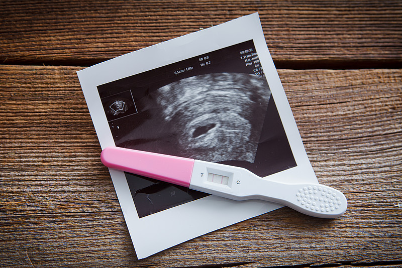 Positiver Schwangerschaftstest mit Ultraschallbild
