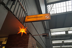 Schild der Bahnhofsmission mit orangem Stern