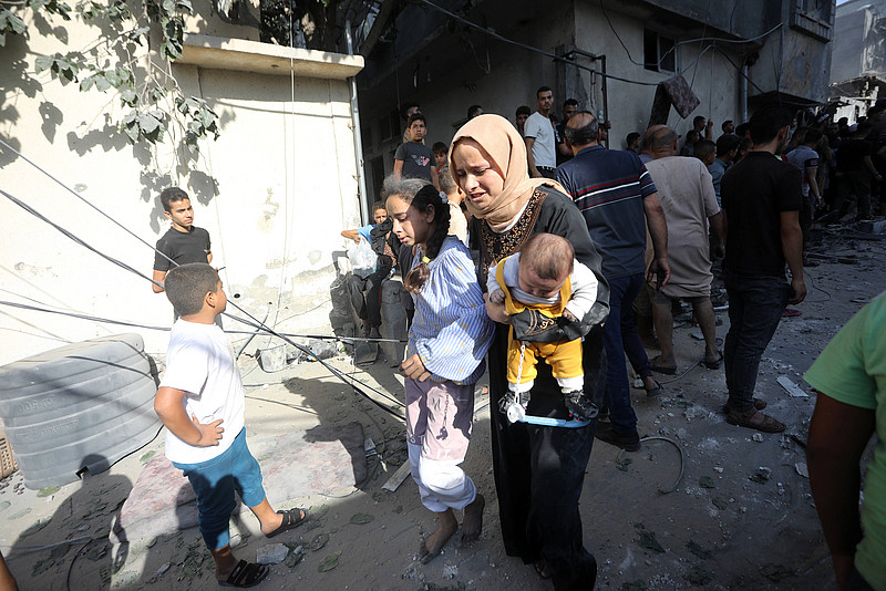 Eine palästinensische Frau flieht mit ihren Kindern nach einem israelischen Angriff im Gazastreifen.