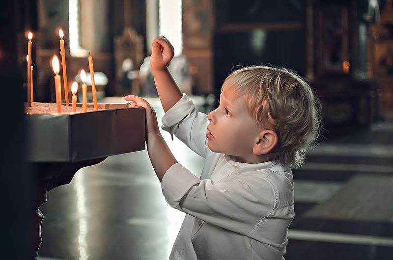 Kind schaut auf Kerzen
